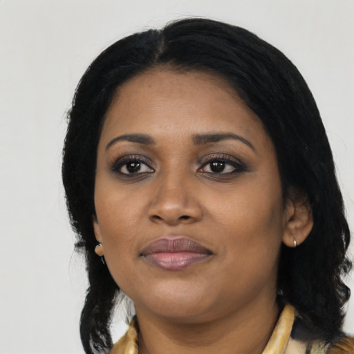 Joyful black young-adult female with long  black hair and brown eyes