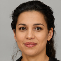 Joyful latino adult female with medium  brown hair and brown eyes