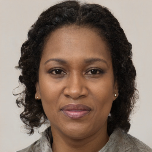 Joyful black adult female with medium  brown hair and brown eyes