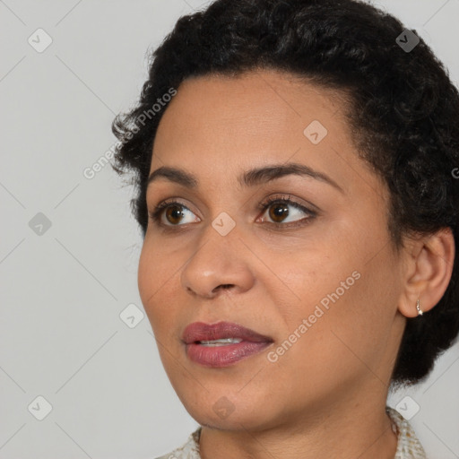 Joyful black young-adult female with short  brown hair and brown eyes