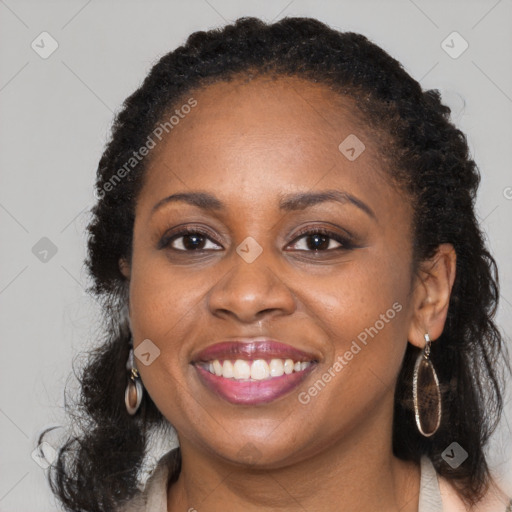 Joyful black adult female with long  brown hair and brown eyes