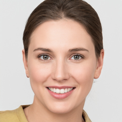 Joyful white young-adult female with medium  brown hair and grey eyes