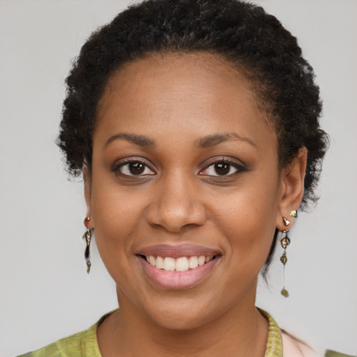 Joyful black young-adult female with short  brown hair and brown eyes