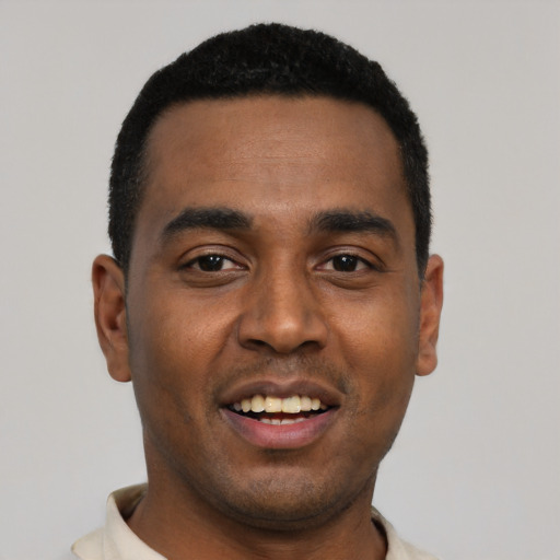 Joyful black young-adult male with short  black hair and brown eyes