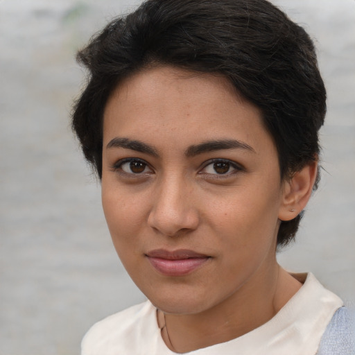 Joyful latino young-adult female with short  brown hair and brown eyes