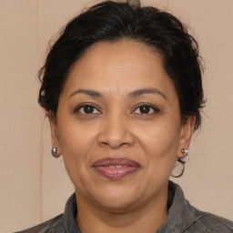 Joyful latino adult female with medium  brown hair and brown eyes