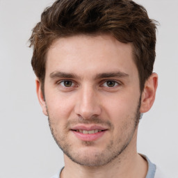 Joyful white young-adult male with short  brown hair and grey eyes