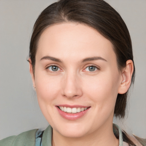 Joyful white young-adult female with medium  brown hair and grey eyes