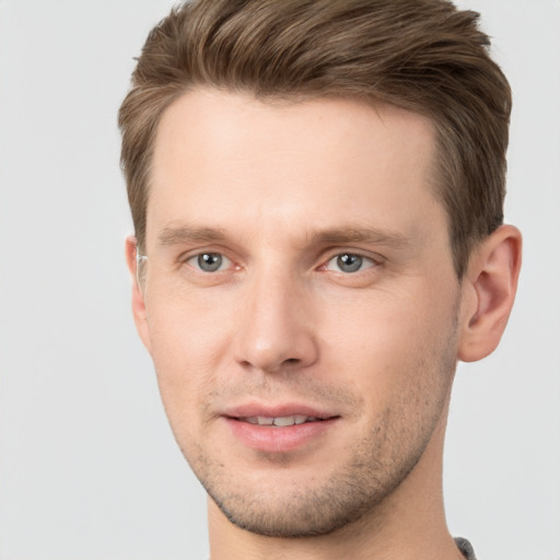 Joyful white young-adult male with short  brown hair and grey eyes