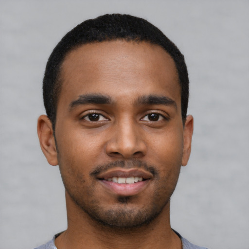 Joyful black young-adult male with short  brown hair and brown eyes