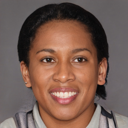 Joyful black adult female with short  brown hair and brown eyes