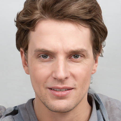 Joyful white adult male with short  brown hair and blue eyes