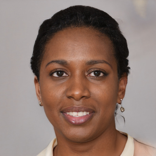 Joyful black young-adult female with short  black hair and brown eyes