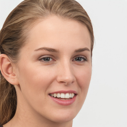 Joyful white young-adult female with long  brown hair and grey eyes