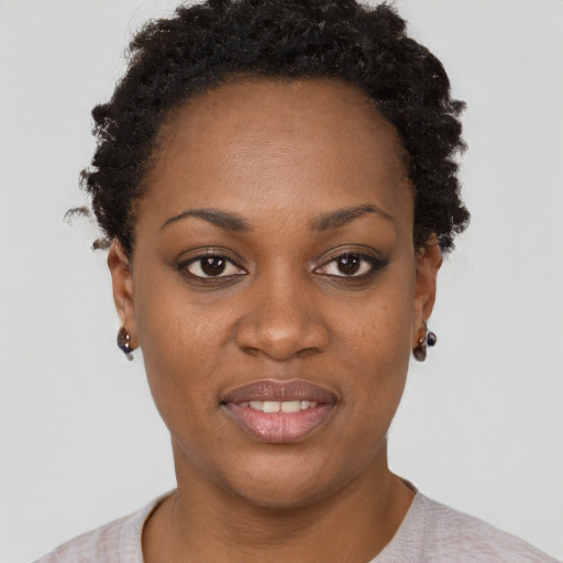 Joyful black young-adult female with short  black hair and brown eyes