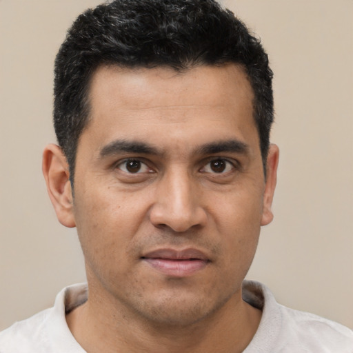Joyful latino young-adult male with short  brown hair and brown eyes
