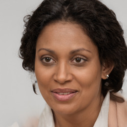 Joyful black adult female with long  brown hair and brown eyes