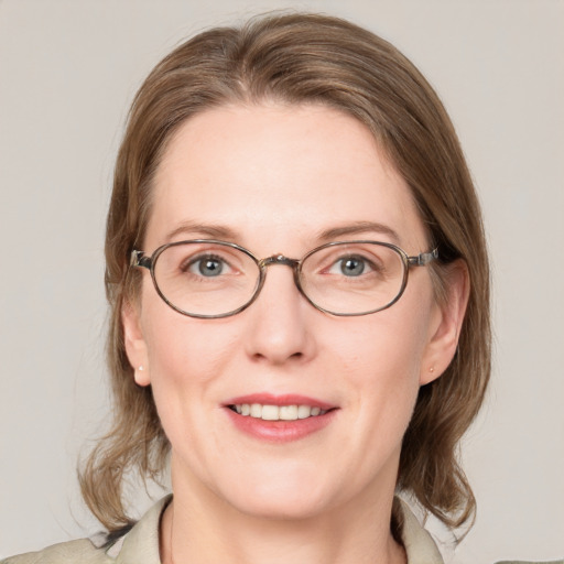 Joyful white adult female with medium  brown hair and blue eyes