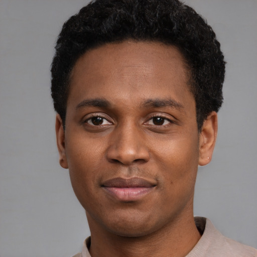 Joyful black young-adult male with short  black hair and brown eyes