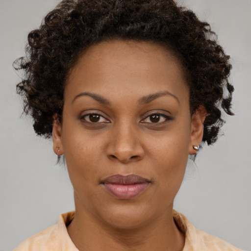 Joyful black young-adult female with short  brown hair and brown eyes