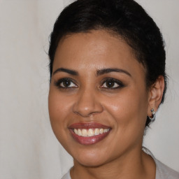 Joyful latino young-adult female with medium  brown hair and brown eyes