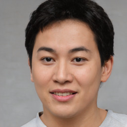 Joyful asian young-adult male with short  brown hair and brown eyes