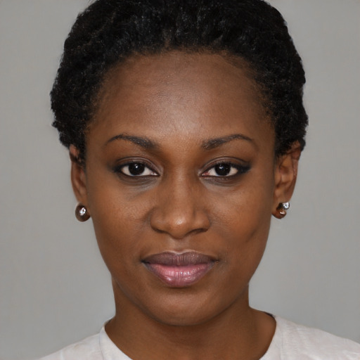 Joyful black young-adult female with short  black hair and brown eyes