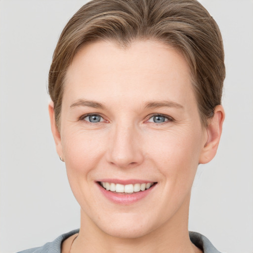 Joyful white young-adult female with short  brown hair and grey eyes