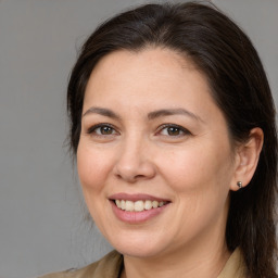 Joyful white adult female with medium  brown hair and brown eyes