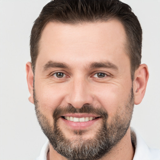 Joyful white adult male with short  brown hair and brown eyes