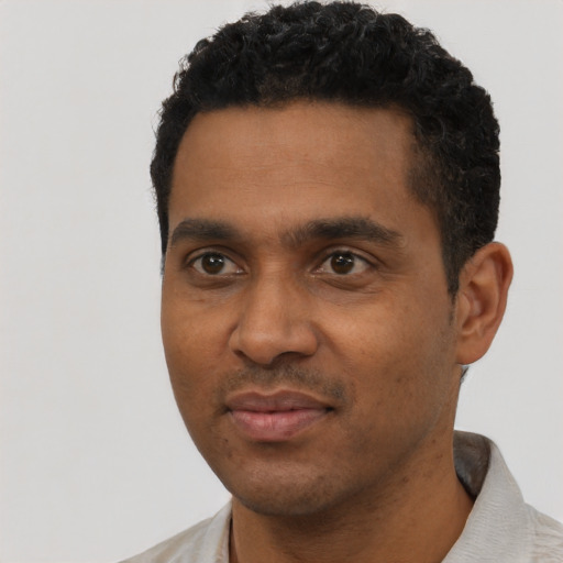 Joyful black young-adult male with short  black hair and brown eyes