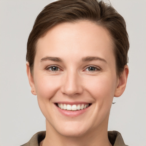 Joyful white young-adult female with short  brown hair and grey eyes