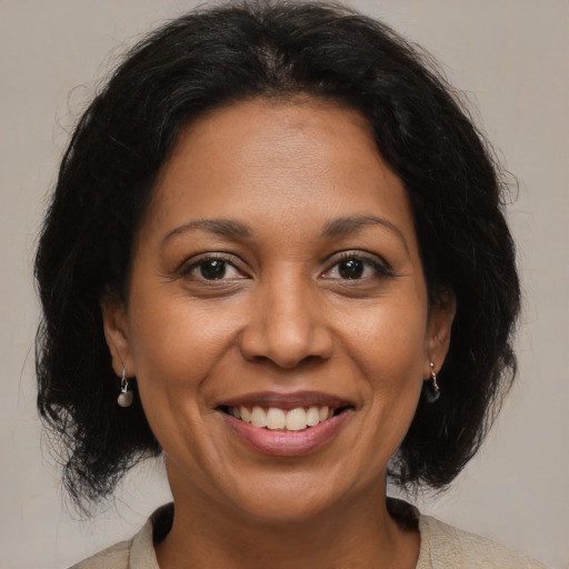 Joyful latino adult female with medium  black hair and brown eyes