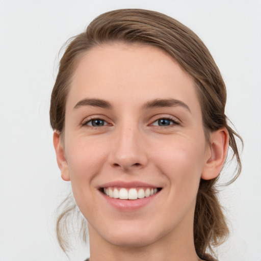 Joyful white young-adult female with medium  brown hair and green eyes