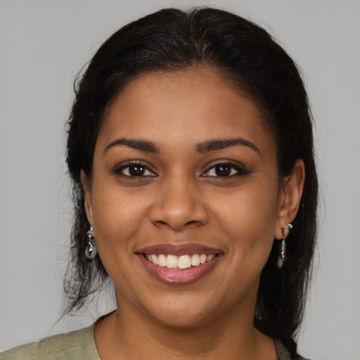 Joyful black young-adult female with medium  brown hair and brown eyes