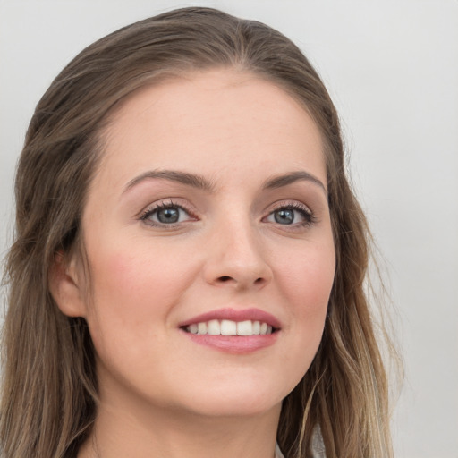 Joyful white young-adult female with long  brown hair and grey eyes