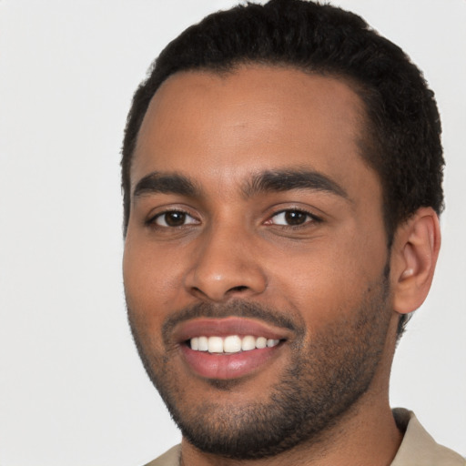 Joyful black young-adult male with short  black hair and brown eyes