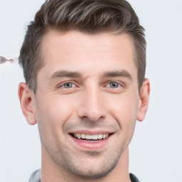 Joyful white young-adult male with short  brown hair and grey eyes