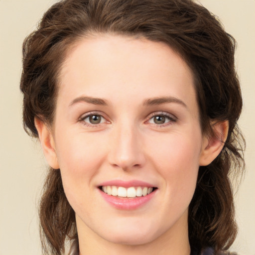 Joyful white young-adult female with long  brown hair and green eyes