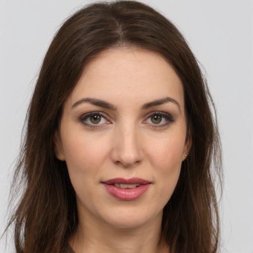 Joyful white young-adult female with long  brown hair and brown eyes