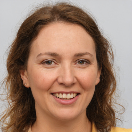 Joyful white adult female with medium  brown hair and grey eyes