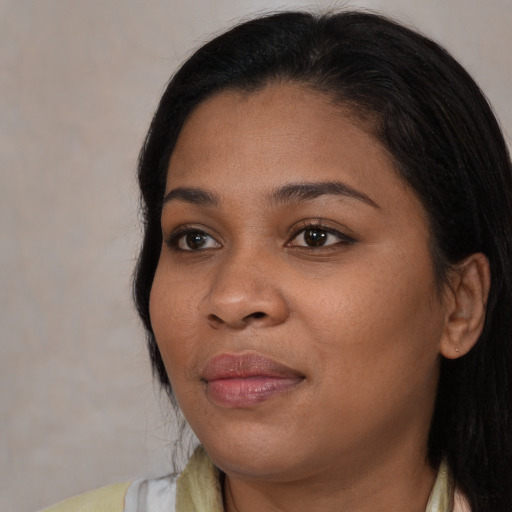 Joyful black young-adult female with long  brown hair and brown eyes