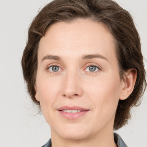 Joyful white adult female with medium  brown hair and grey eyes