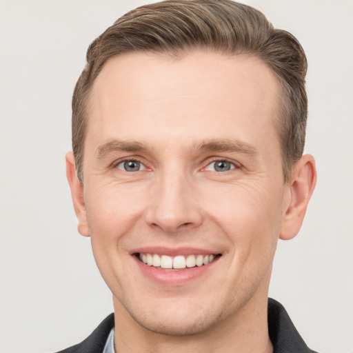 Joyful white young-adult male with short  brown hair and grey eyes