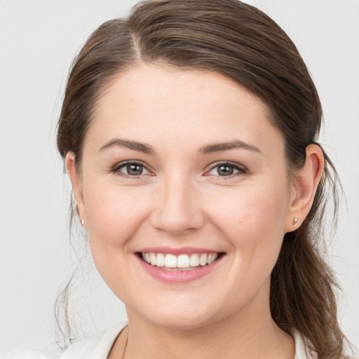 Joyful white young-adult female with medium  brown hair and grey eyes