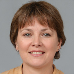 Joyful white adult female with medium  brown hair and grey eyes