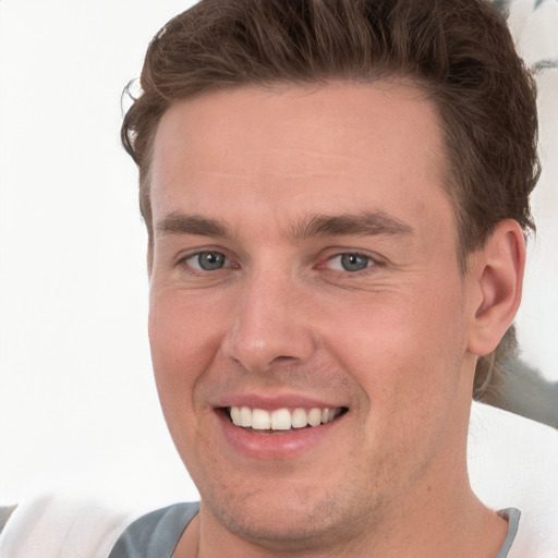 Joyful white young-adult male with short  brown hair and grey eyes