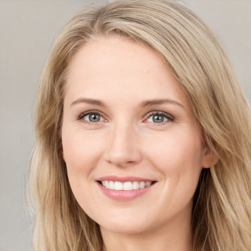 Joyful white young-adult female with long  brown hair and blue eyes