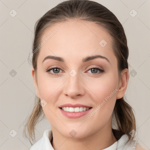 Joyful white young-adult female with medium  brown hair and grey eyes