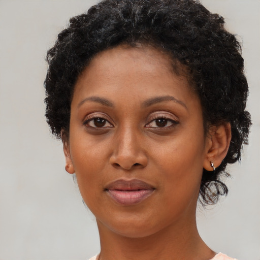 Joyful black young-adult female with short  brown hair and brown eyes